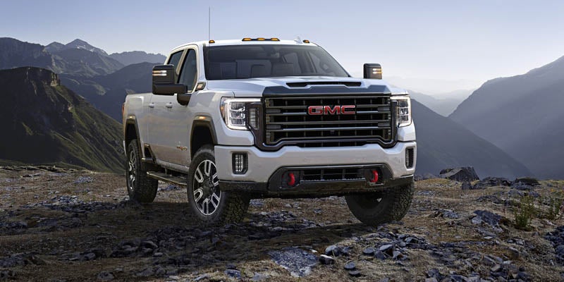 GMC Sierra 2500HD parked on rocky ground surrounded by mountains