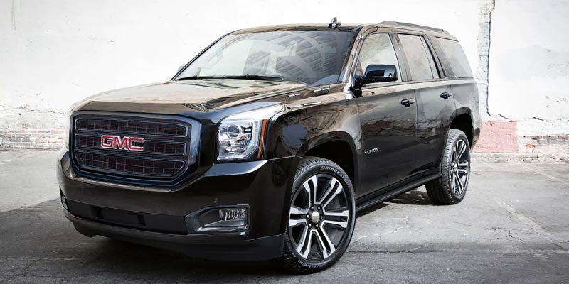 GMC Yukon parked cross view on black surface