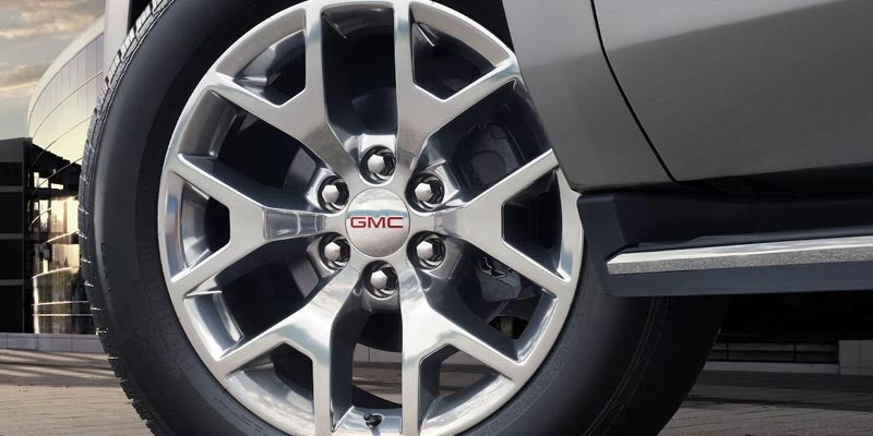 GMC Yukon front alloy wheel view surrounded by buildings